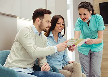 Woman in scrubs showing brochure to patients