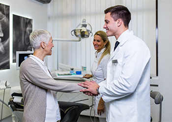 Dentist and patient shaking hands