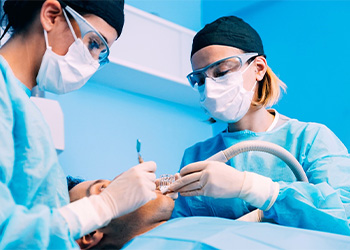 Two oral surgeons treating a patient