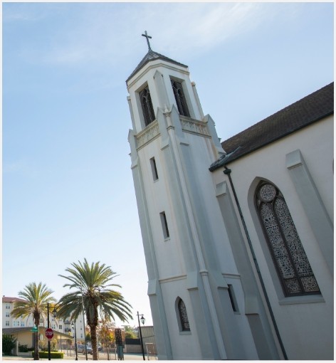 Exterior of church with palm trees in background