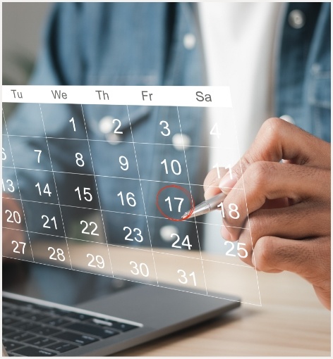 Person circling a date on a hologram of a monthly calendar