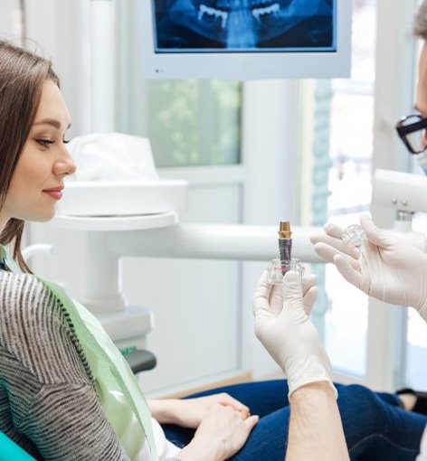 Patient holding a dental implant and talking to a patient