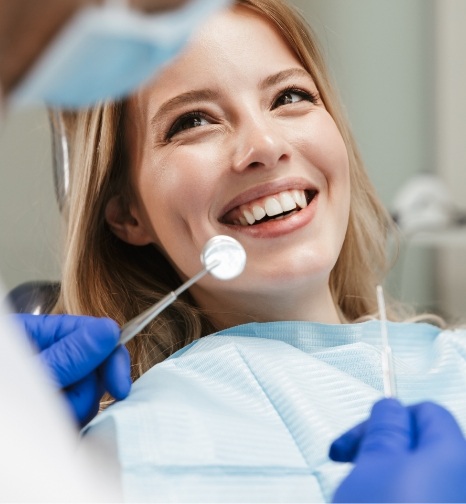 Woman in dental chair smiling at her dentist