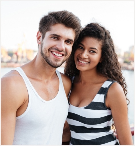 Young man and woman smiling on the beach together