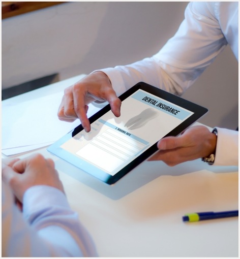 Two people looking at dental insurance information on a tablet