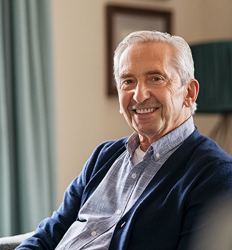 Senior man smiling on couch at home