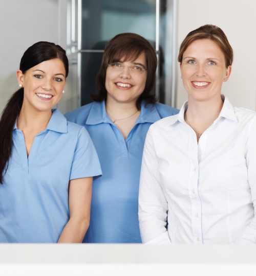 Three smiling dental team members