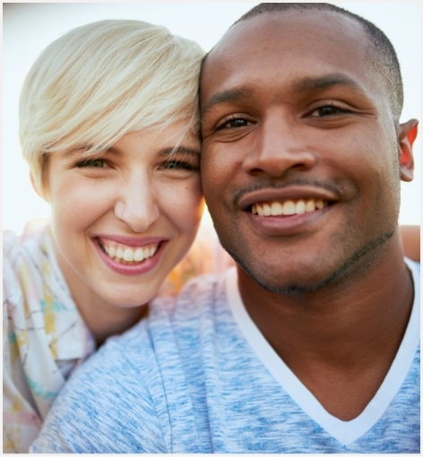 Man and woman smiling together after restorative dentistry in Hayward