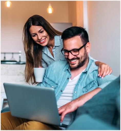 Man and woman looking at laptop for dentist reviews in Hayward