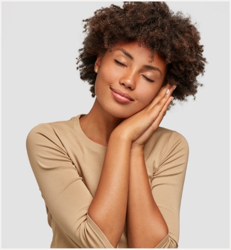 Woman making pillow shape with her hands and pretending to sleep