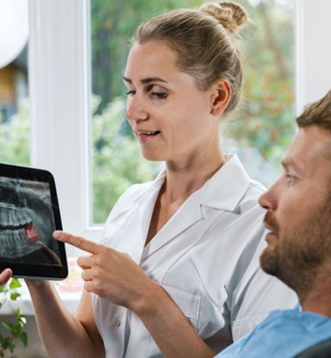 Patient and dental team member reviewing X-ray