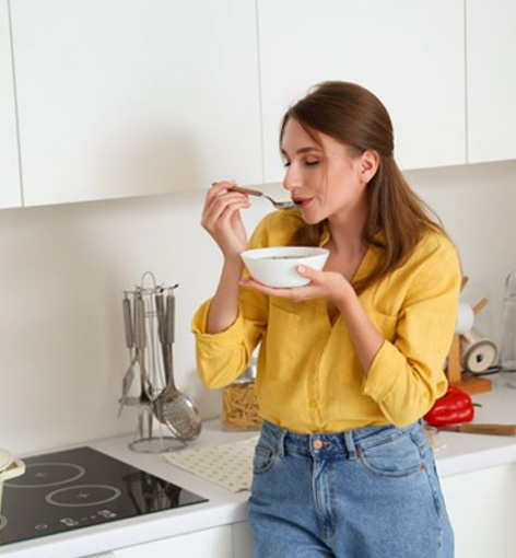 Woman eating soup after wisdom tooth procedure